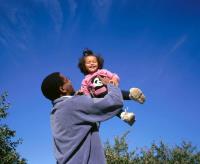 dad holding small daughter in air